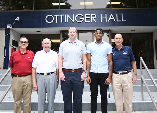 Franklin Almonte and others posing in front of Ottinger Hall