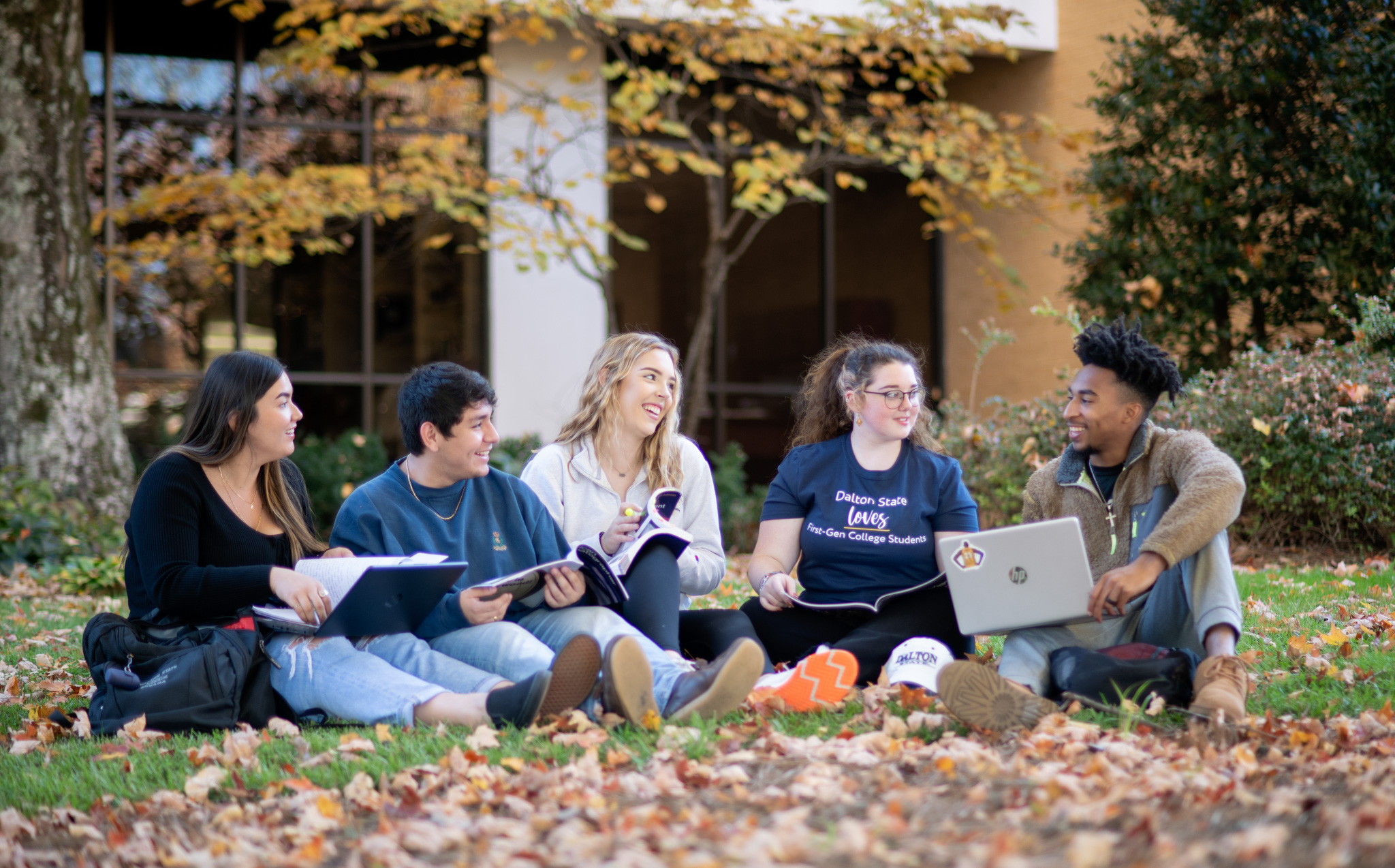 students on lawn in front of library in fall