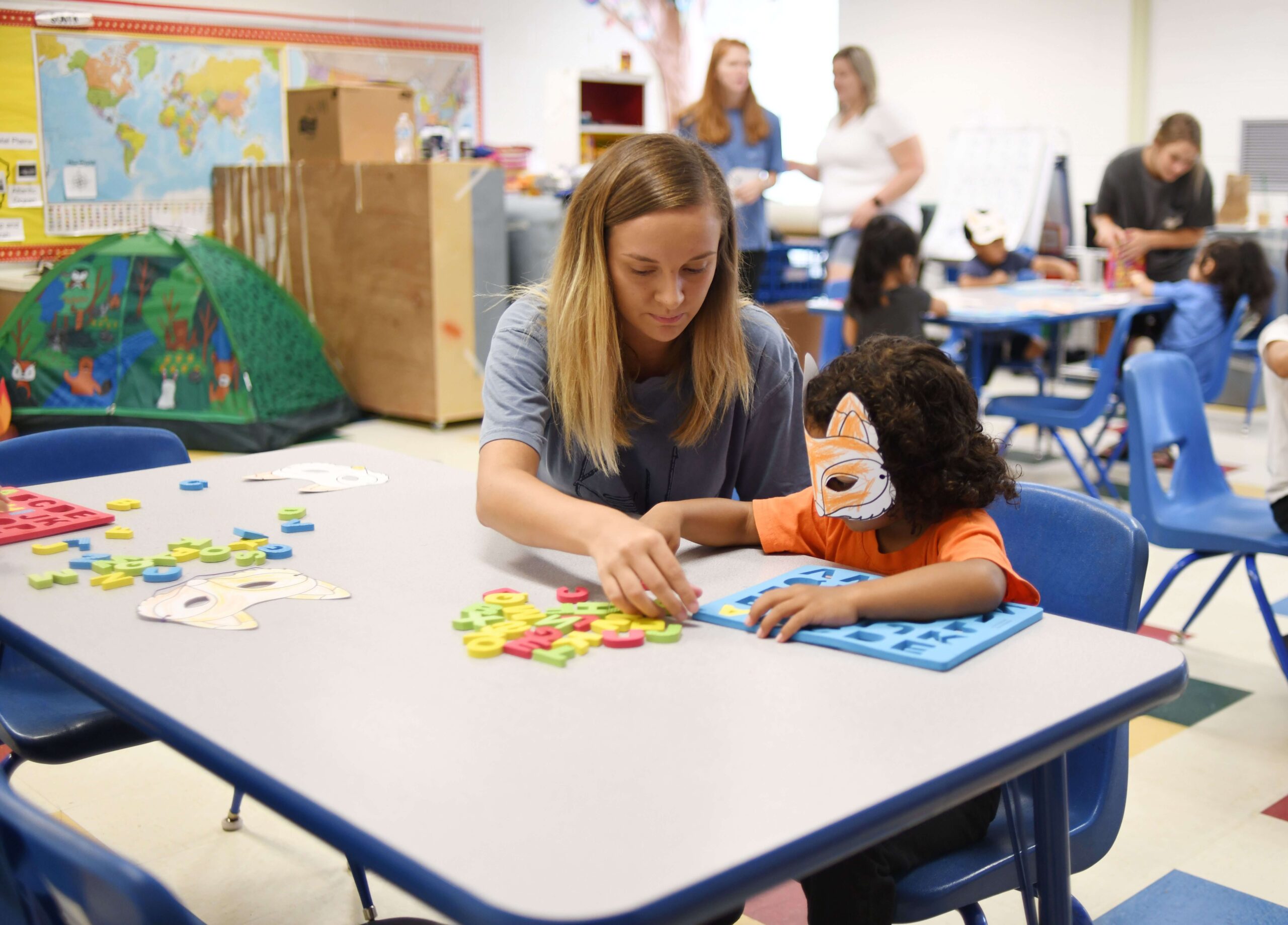 young student being assisted in recognizing letters