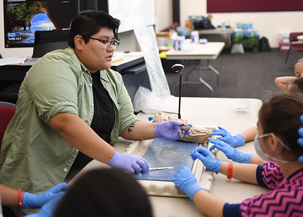 Student teacher demonstrating to young students