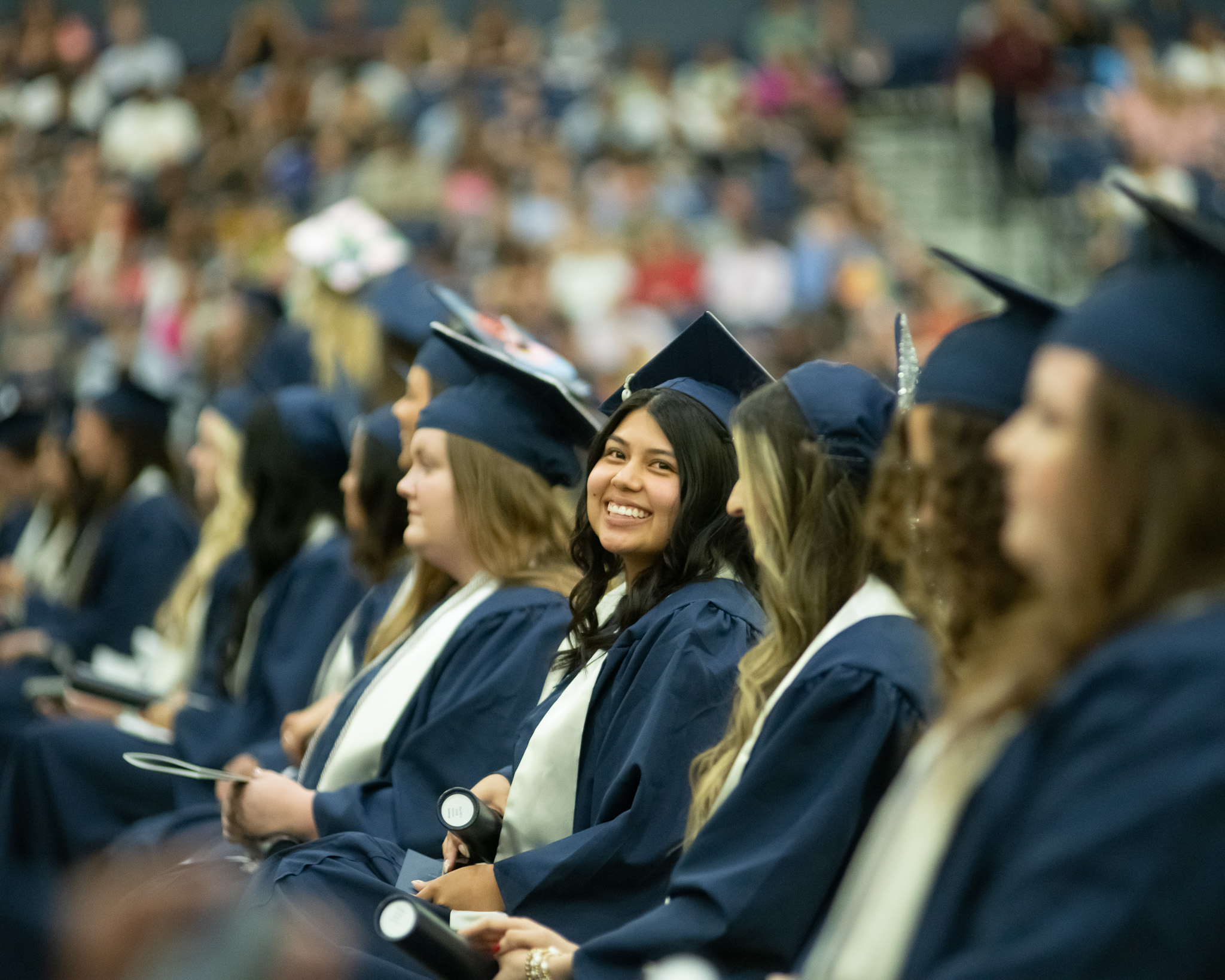 Students sitting at a commencement ceremony in regalia.
