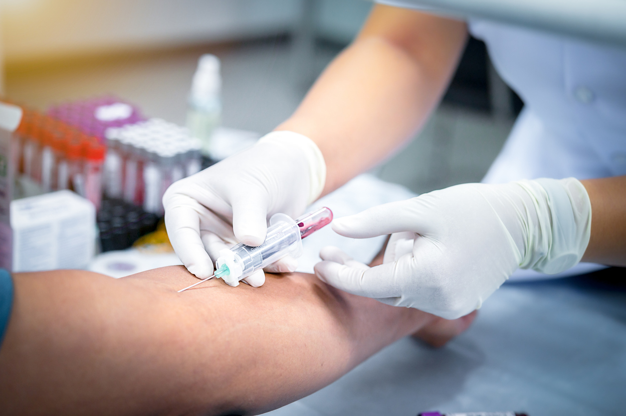 A phlebotomist draws a patient's blood