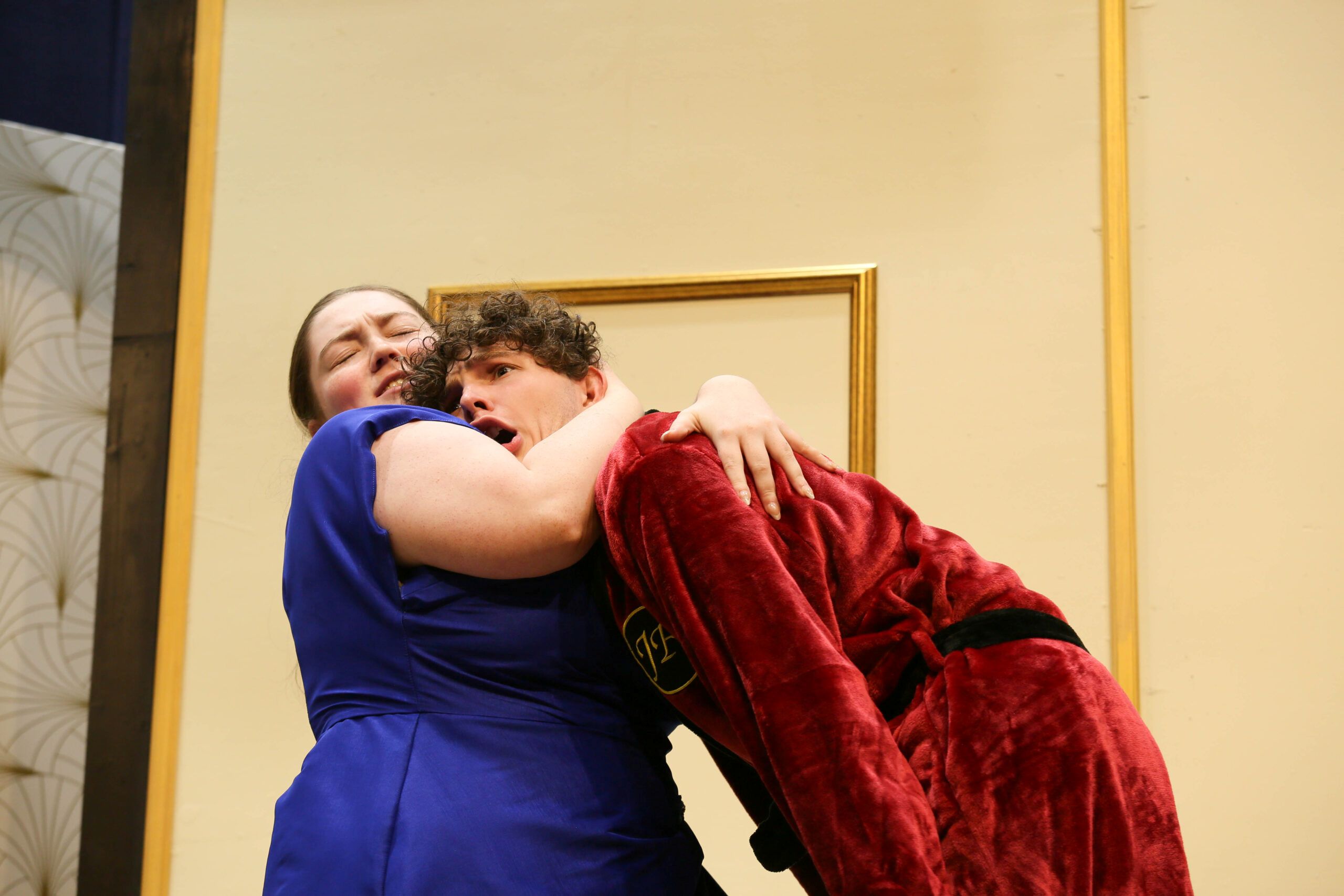 Photo from Dalton State Theater's dress rehearsal showing an actress pulling an actor in for an embrace.